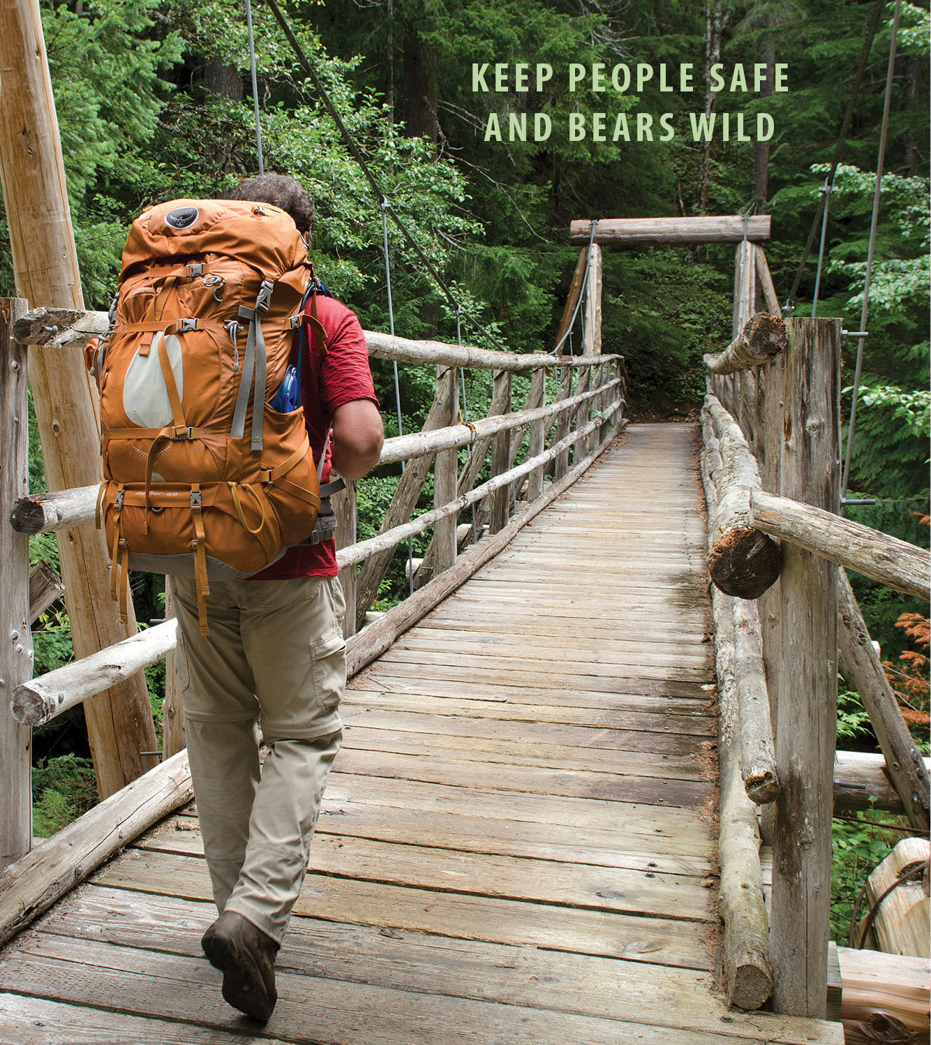 backpacker on foot bridge, entering bear country